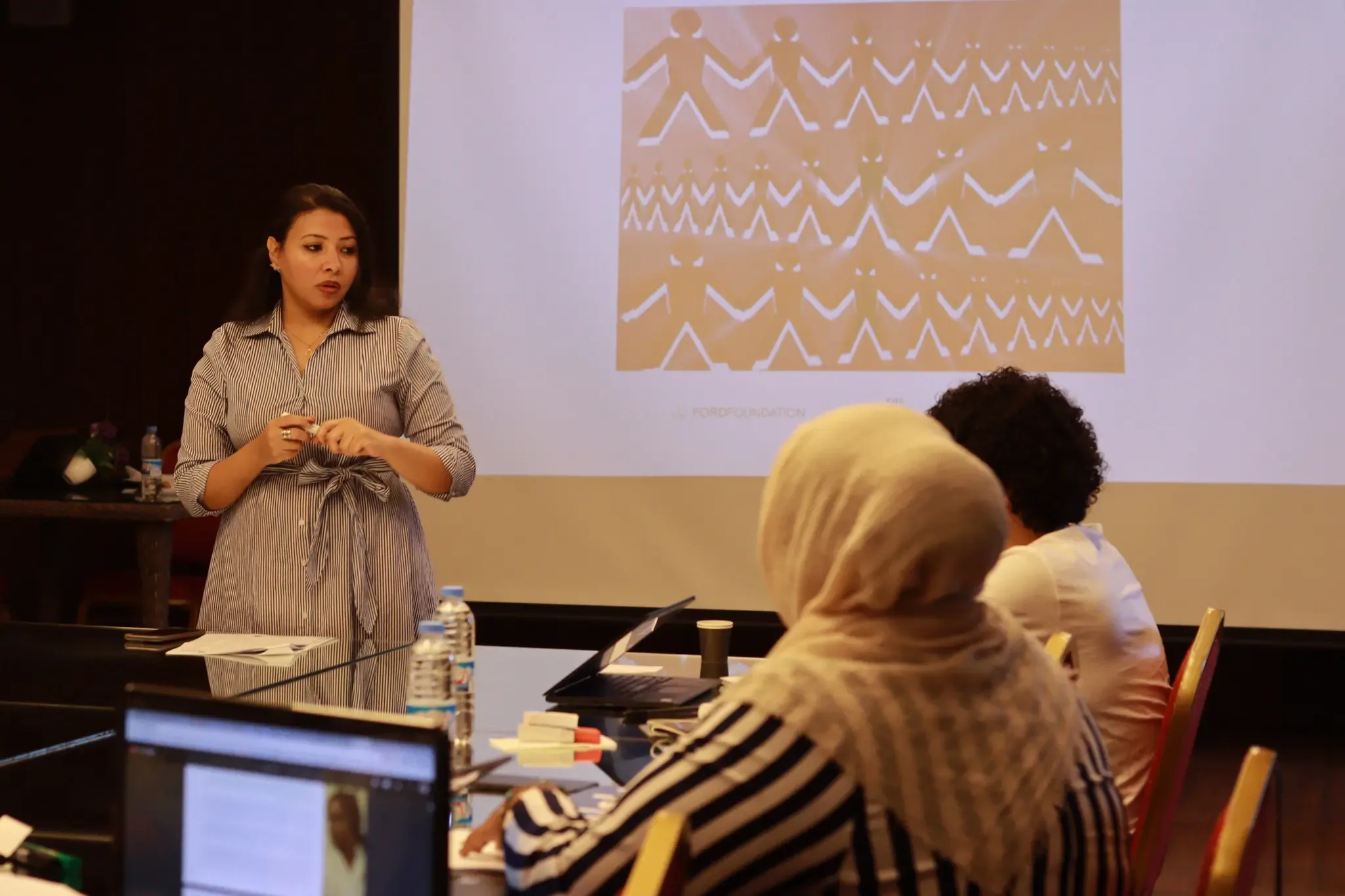 A speaker presenting to a seated audience at a workshop