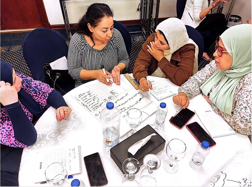 Women working together around a table at a workshop